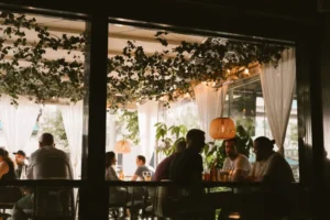 Gäster som äter en kväll på Joe Farelli's uteservering på Avenyn i Göteborg, med hängande grönska och lyktor