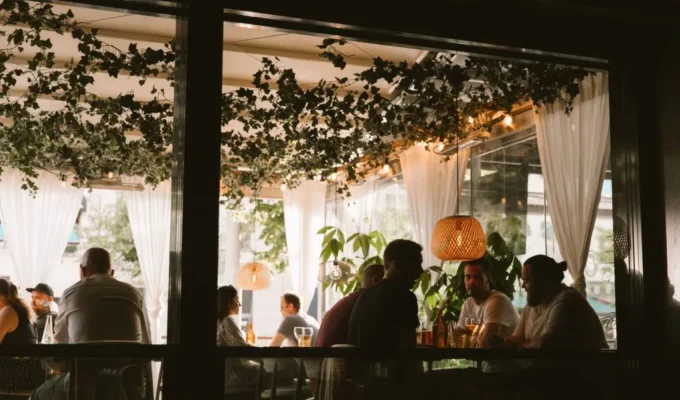 Gäster som äter en kväll på Joe Farelli's uteservering på Avenyn i Göteborg, med hängande grönska och lyktor
