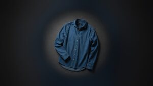 Blå denimskjorta mot mörk bakgrund, exempel på en profilprodukt som kan ges som företagsgåva