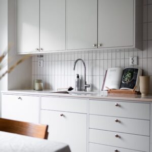 Platsbyggt kök med integrerad diskmaskin och infräst belysning under överskåpen