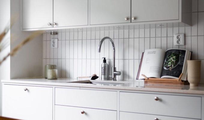 Platsbyggt kök med integrerad diskmaskin och infräst belysning under överskåpen