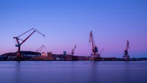 Kranarna vid Göteborgs hamn i skymning. Foto: Nikola Johnny Mirkovic / Unsplash